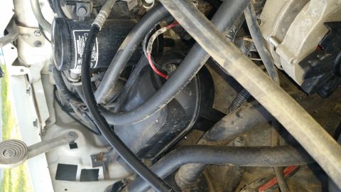 1992 Ford Bronco - Close-up view of engine bay components, including a vacuum canister and various hoses.