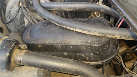 1992 Ford Bronco - Close-up view of a vacuum canister and hoses within an engine bay.
