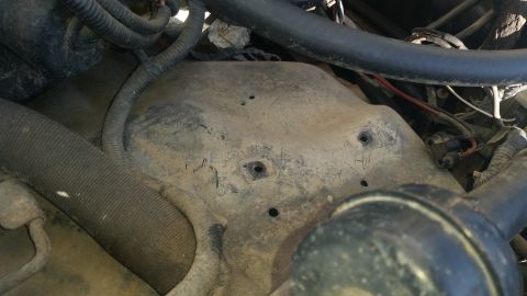 1992 Ford Bronco - This image shows a section of an engine bay with various hoses and a dusty metal component.