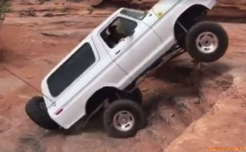 1979 Ford Bronco - White SUV navigates a rocky off-road course, demonstrating its suspension capabilities.