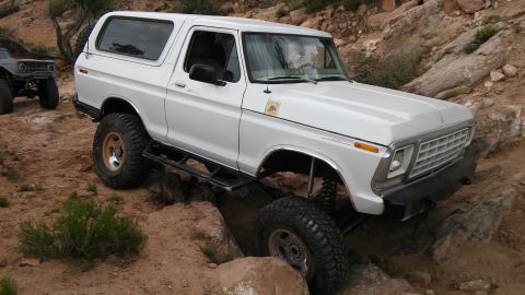 1979 Ford Bronco - This 1979 Ford Bronco is shown tackling a challenging off-road course with another vehicle visible in the background.