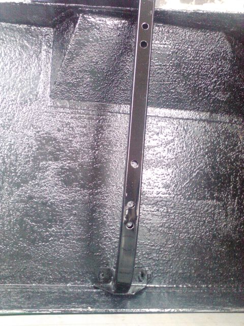 1991 Ford Bronco - The textured surface of the vehicle's cargo area is visible, along with a metal support.