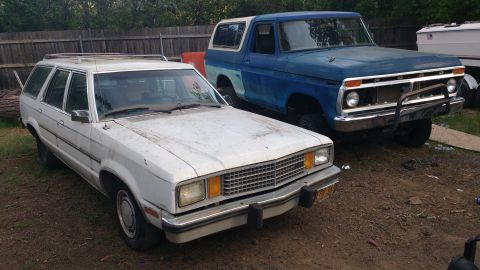 1980 Ford Fairmont - Two vehicles are parked outdoors: a white 1980 Ford Fairmont station wagon and a blue pickup truck.