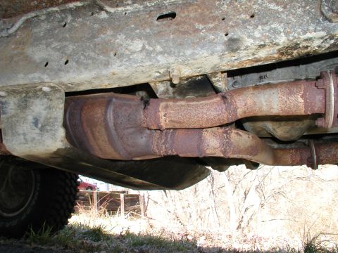 1990 Ford Bronco - The exhaust system and undercarriage of the vehicle show significant rust and wear.