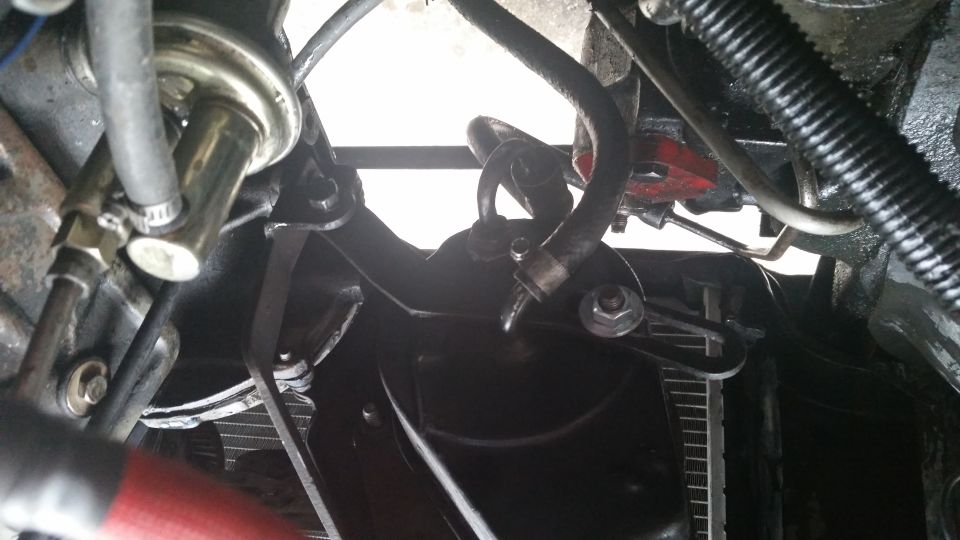 Close-up of hoses and brackets in a vehicle's engine bay