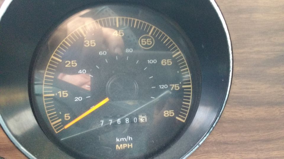 Speedometer gauge with yellow needle, showing 77680 miles and 55 mph