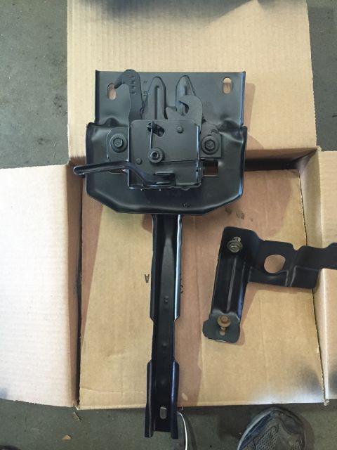 1978 Ford Bronco - A close-up view of a vehicle's hood latch mechanism and a separate mounting bracket.