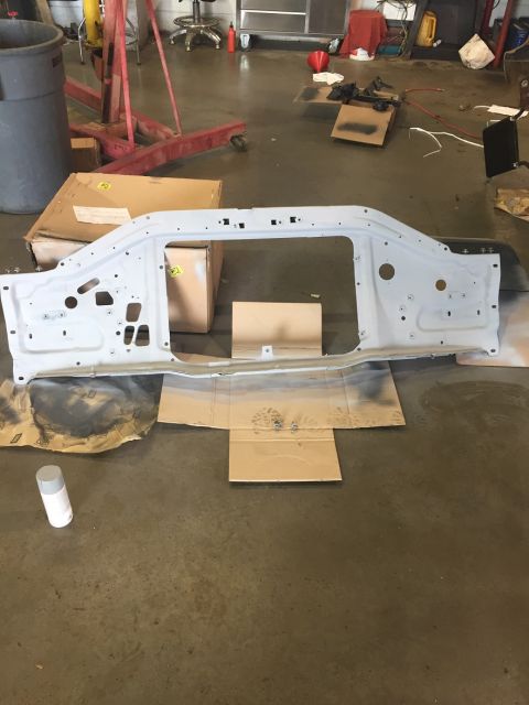 1978 Ford Bronco - A car's front radiator support structure is laid out on the floor, ready for restoration work.