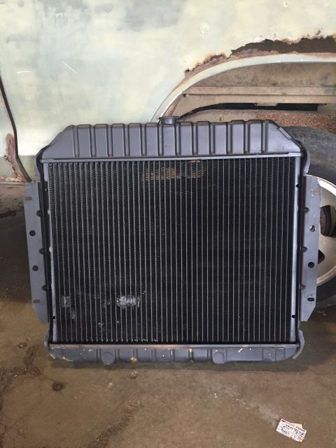 1978 Ford Bronco - A radiator is shown in front of a rusty vehicle body.
