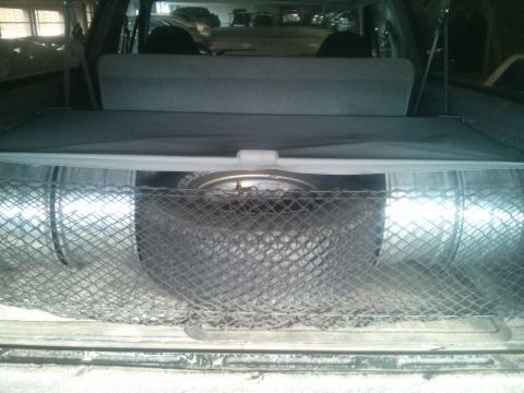 1995 Ford Bronco - Rear cargo area with spare tire and cover deployed.
