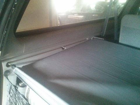 1995 Ford Bronco - The retractable cargo cover is shown extended, revealing its mounting hardware and fabric.