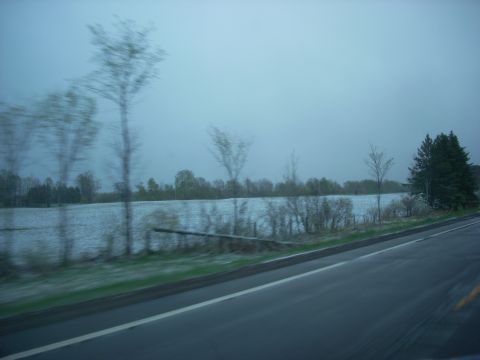1963 Hummer H3 - A blurry roadside scene shows a field with scattered snow and trees, with a watermark at the bottom right.