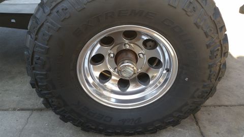 1992 Ford Bronco - This image shows a close-up of a vehicle's tire and wheel assembly, a knobby tread pattern and a polished rim.