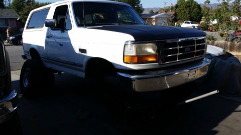1992 Ford Bronco - This lifted 1992 Ford Bronco is shown from the front quarter angle, highlighting its modified suspension and large tires.