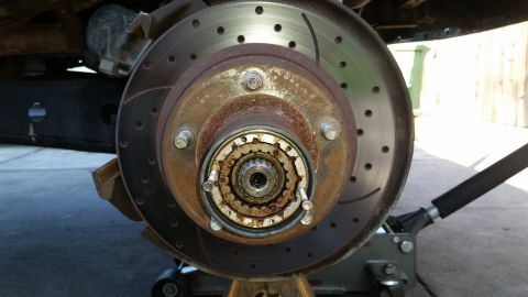 1992 Ford Bronco - Close-up of a vehicle's front wheel hub and brake rotor assembly, showing signs of wear and rust.