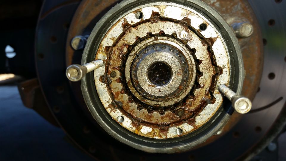 Rusty manual locking hub with visible gear teeth and bolts