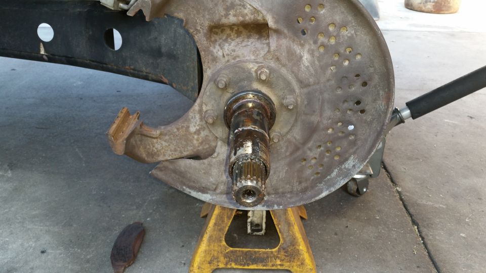 Rusty front wheel hub assembly of a 1992 Ford Bronco on jack stands