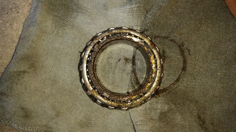 1992 Ford Bronco - A dirty, worn wheel bearing sits on a piece of cloth.