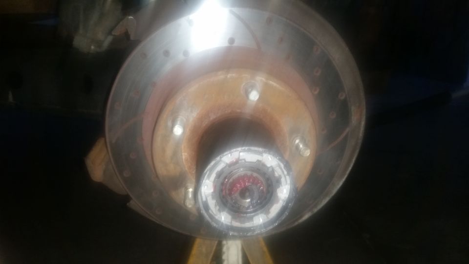 Close-up of a vehicle's front wheel hub assembly with a brake rotor visible