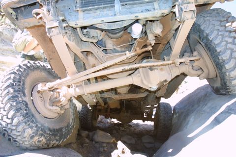 1987 Ford Bronco - The underside of a 4x4 vehicle shows significant modifications, including a solid axle, suggesting off-road use.