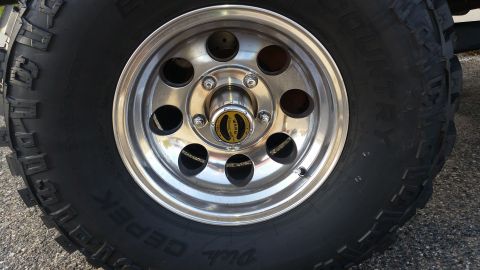 1992 Ford Bronco - Chrome wheel and Warn locking hub on a vehicle's tire.