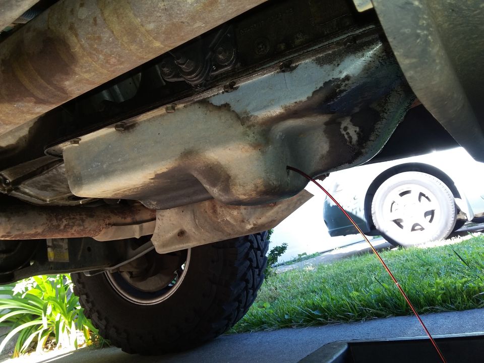 Transmission pan and exhaust pipe of a 1996 Ford Bronco, with a drip pan below