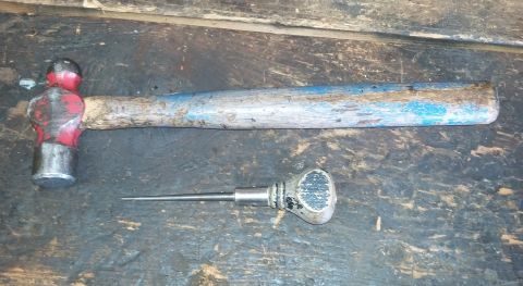 1996 Ford Bronco - A ball-peen hammer and an awl are shown resting on a wooden surface.