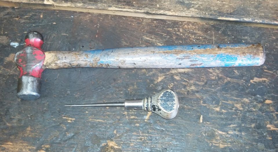 Ball-peen hammer and awl on a workbench