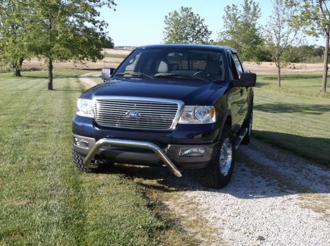 2005 Ford F-150 - This dark blue 2005 Ford F-150 is captured from the front, its prominent chrome grille and a protective bull bar.