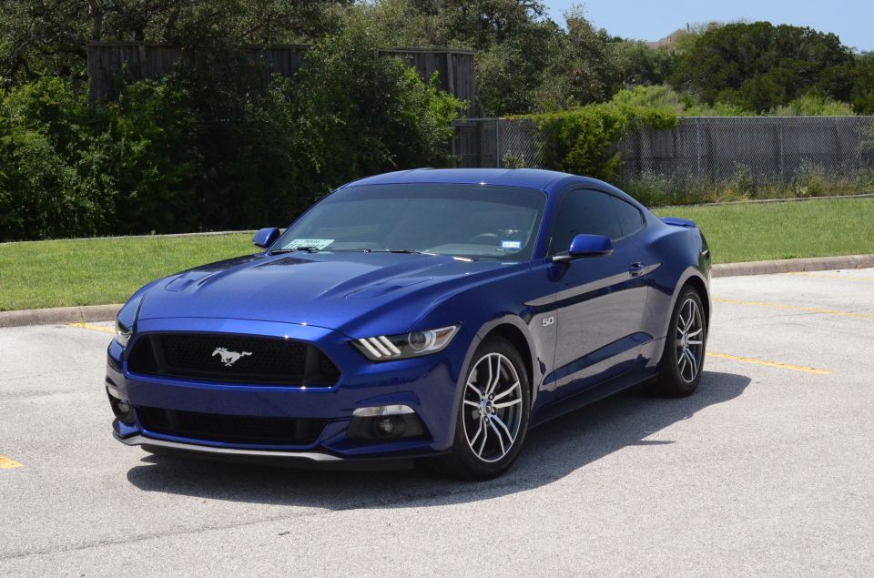 Blue 2015 Ford Mustang coupe parked on asphalt