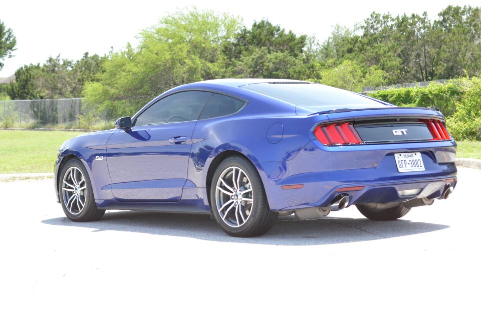 Blue 2015 Ford Mustang GT coupe, rear 3/4 view. Texas license plate GFP-3882