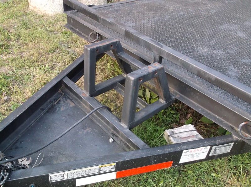 Trailer frame with metal wheel chocks welded to the tongue
