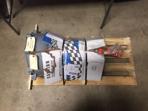 1982 Ford Bronco - Gray transmission and boxed parts are secured on a wooden pallet.