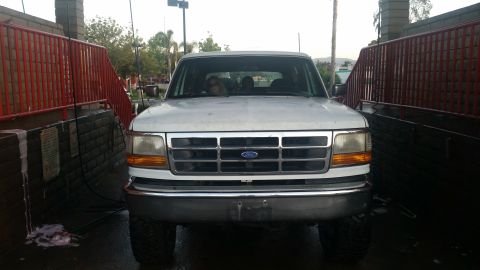 1992 Ford Bronco - Front view of a white 1992 Ford Bronco, possibly at a car wash.