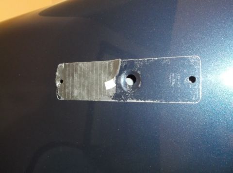 2005 Ford F-150 - This photo shows a removed emblem mount on a vehicle's body panel, with tape residue present.