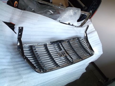 2005 Ford F-150 - A shiny chrome grille, likely for a truck, is shown disassembled and protected for shipping.