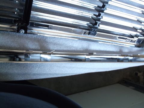 2005 Ford F-150 - Close-up of a vehicle's chrome grille and textured material, with 'SUPERMOTORS' text visible.