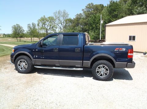 2005 Ford F-150 - This dark blue 2005 Ford F-150 FX4 Off Road pickup truck is shown from the side, parked outdoors.