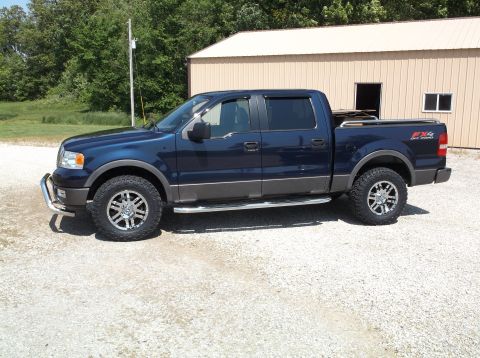 2005 Ford F-150 - Side view of a dark blue crew cab pickup truck with FX4 Off Road badging.