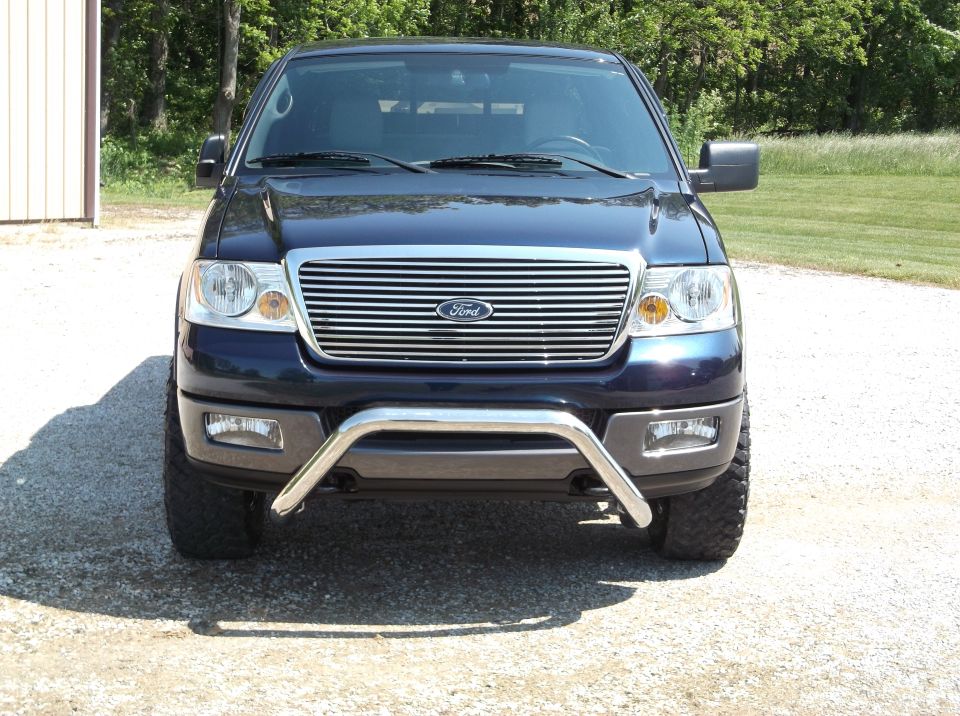 Front view of a dark blue Ford F-150 pickup truck with a chrome grille and bull bar