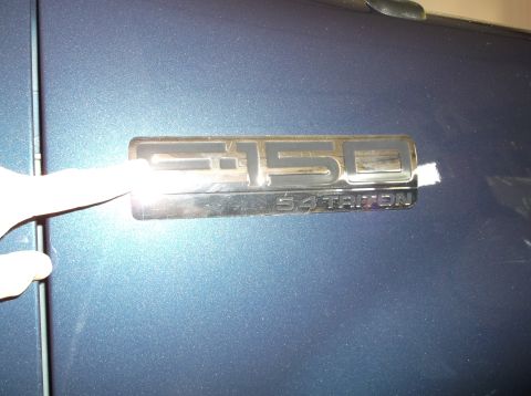 2005 Ford F-150 - A close-up view of the F-150 5.4 Triton emblem on the side of a vehicle.