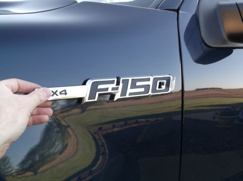 2005 Ford F-150 - F-150 X4 badge is shown on the side of a dark blue truck, matching the 2005 model year claim.