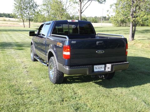 2005 Ford F-150 - Rear view of a dark blue Ford F-150 pickup truck with FX4 Off Road badging, parked on a grassy lawn.