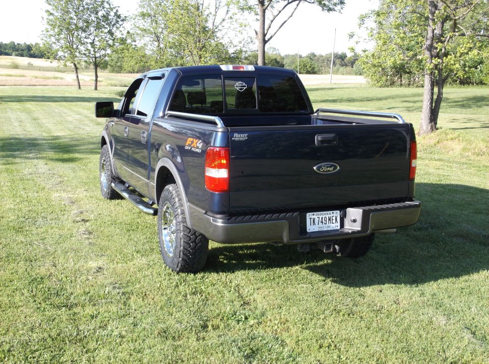 Dark blue Ford F-150 pickup truck parked on grass. Has FX4 Off Road badging