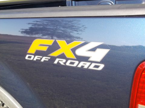 2005 Ford F-150 - Close-up of the FX4 OFF ROAD decal on the side of a blue truck bed.