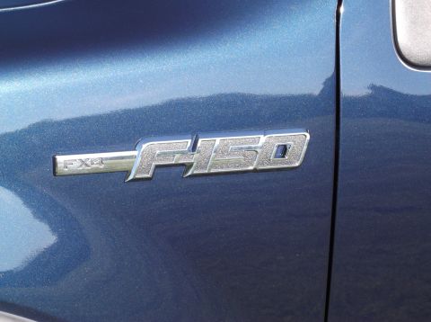 2005 Ford F-150 - Close-up of the F-150 FX4 badge on the side of a blue truck.