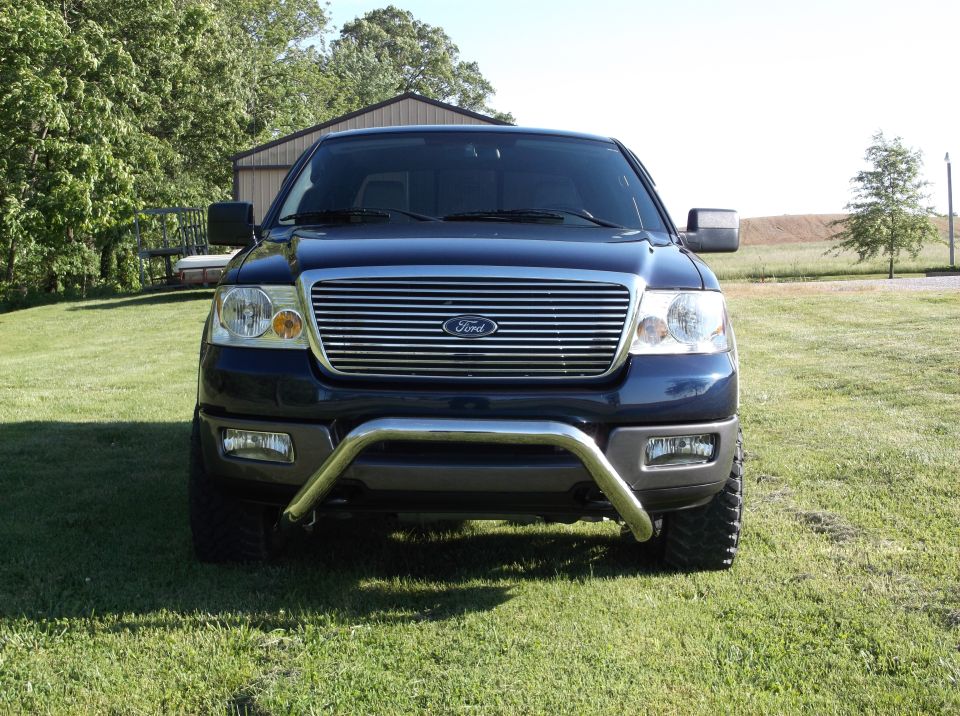 Front view of a dark blue Ford F-150 truck with a chrome grille guard