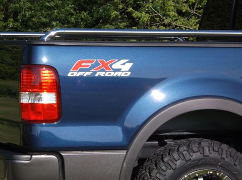 2005 Ford F-150 - Close-up of the FX4 OFF ROAD decal on the side of a blue 2005 Ford F-150 pickup truck.