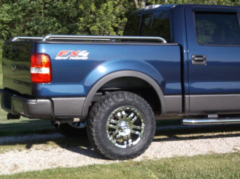 2005 Ford F-150 - Blue Ford F-150 FX4 Off Road pickup truck with aftermarket wheels and side steps.