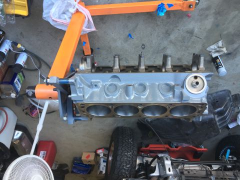 1987 Ford Bronco - Engine block being worked on, supported by an engine stand in a garage setting.